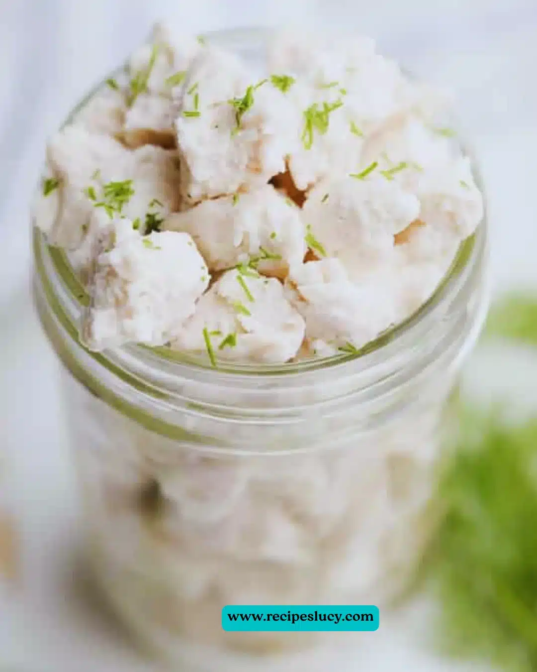 Homemade vegan feta cheese in a bowl, garnished with herbs.