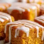 Delicious pumpkin spice snack cake squares arranged on a plate.