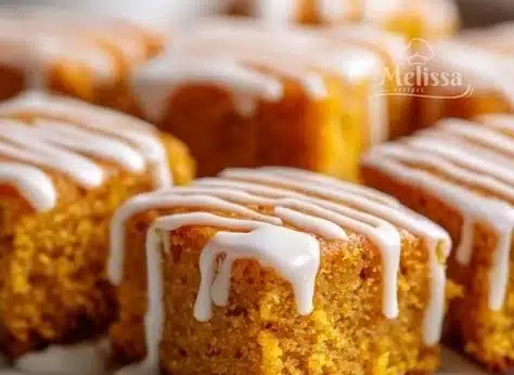 Delicious pumpkin spice snack cake squares arranged on a plate.