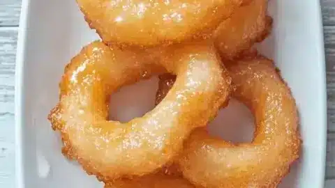 Delicious picarones, sweet potato doughnuts, served with syrup on a plate
