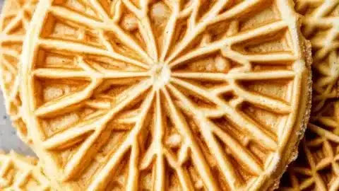 Freshly baked pizzelle cookies on a plate, perfect for sharing with friends.