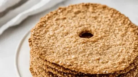 Homemade Swedish Crispbread displayed on a wooden board with toppings