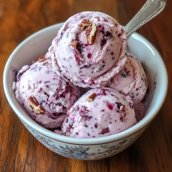 Delicious blackcurrant pecan ice cream in a bowl with nuts and berries