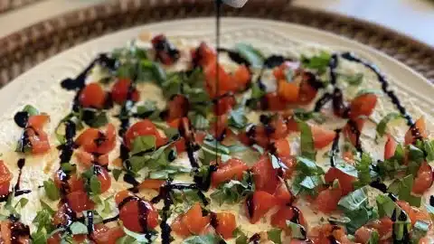 Delicious bruschetta dip served with crusty bread on a rustic wooden table