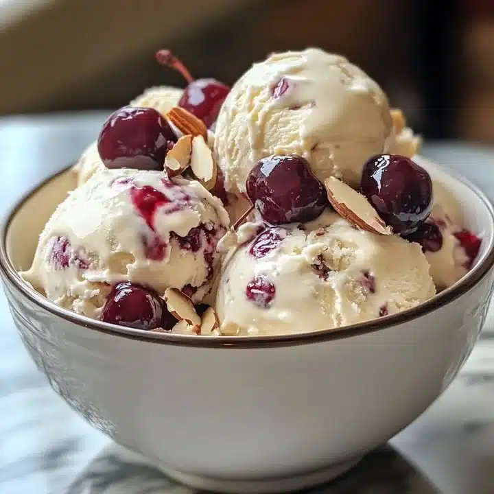 Delicious homemade Cherry Almond Ice Cream in a bowl with fresh cherries.