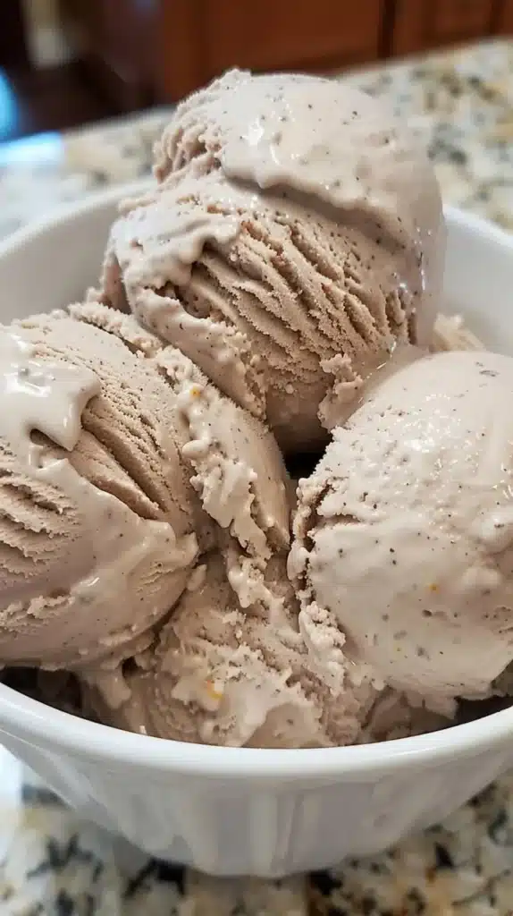 Delicious homemade chocolate orange ice cream in a bowl with a chocolate drizzle