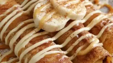 Cinnamon Roll Protein Crepes with icing and cinnamon on a plate