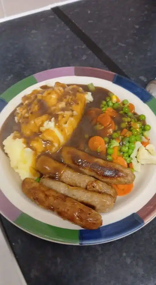 Plate of classic British beef sausages with mashed potatoes and onion gravy