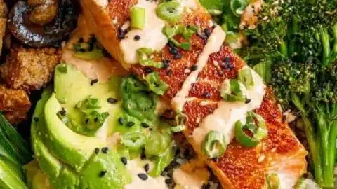 Crispy salmon bowls topped with fresh vegetables and sauce