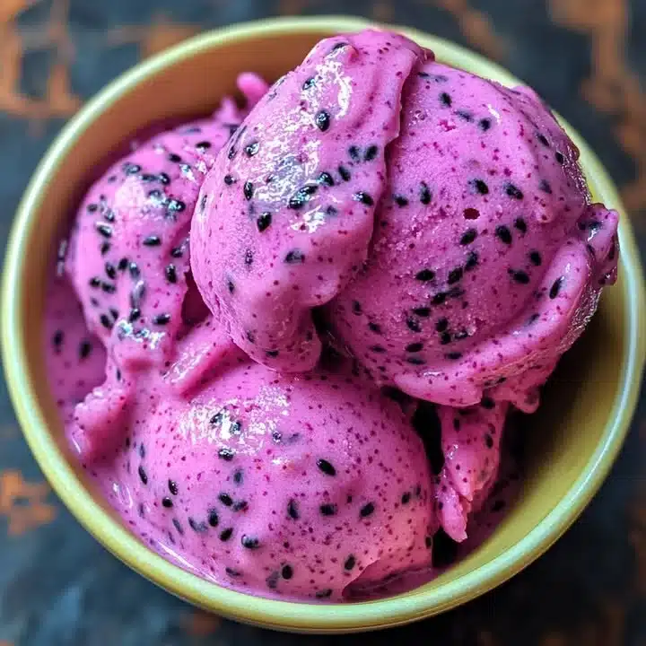 A bowl of creamy dragon fruit cashew ice cream topped with fresh fruit