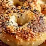 Homemade Greek Yogurt Bagels topped with seeds on a wooden table