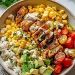 Healthy Chicken Rice Bowl with Street Corn topped with fresh ingredients.