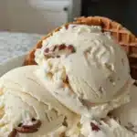 Bowl of homemade butter pecan ice cream with crunchy pecans on top