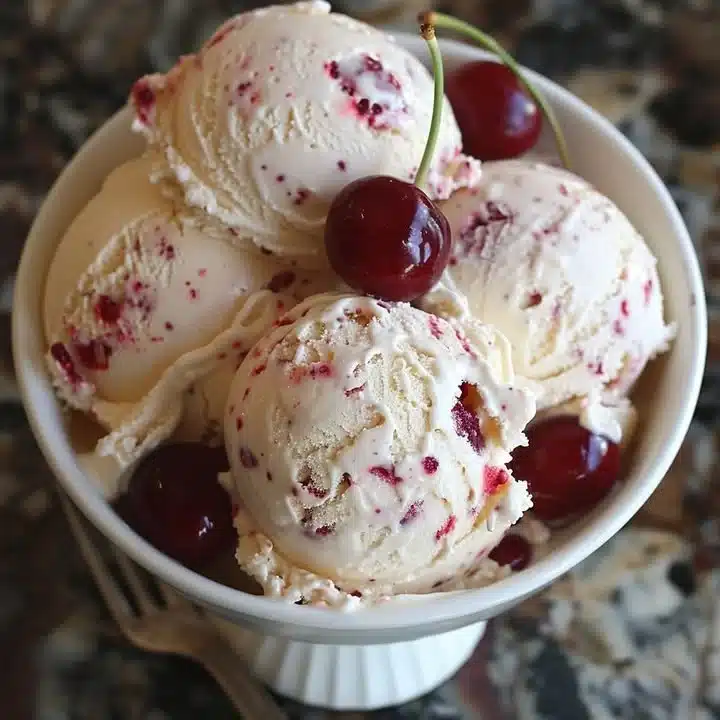 Bowl of homemade cherry amaretto ice cream topped with cherries