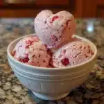Bowl of homemade Cupid's Cherry Bliss Ice Cream with cherry toppings