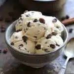 Delicious Jamaican rum raisin ice cream served in a bowl with raisins on top.