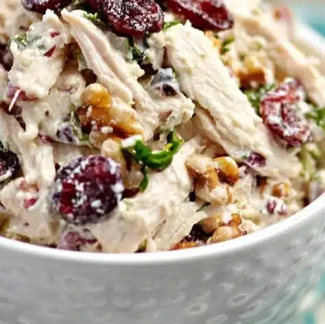 Keto Cranberry Chicken Salad with chicken, cranberries, and greens in a bowl.