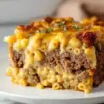 Delicious Mac and Cheese Meatloaf served on a plate, garnished with herbs.
