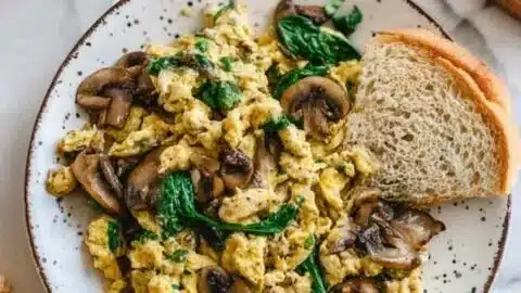 Mushroom spinach scrambled eggs served on a plate.
