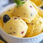 Homemade passion fruit ice cream in a bowl with fresh passion fruit slices