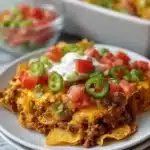 Delicious Walking Taco Casserole topped with cheese and crunchy tortilla chips.