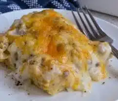 Biscuits and Gravy Breakfast Casserole topped with cheese and herbs