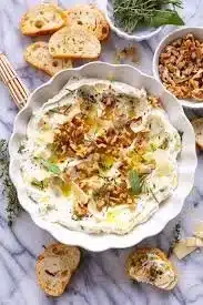 Delicious Boursin cheese appetizers served on a platter with herbs and crackers.