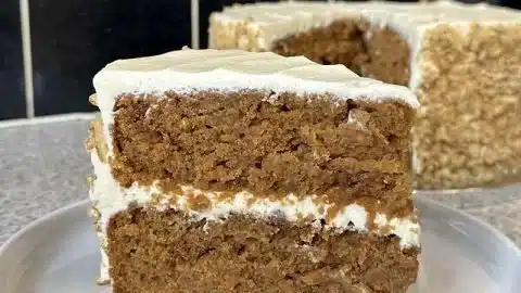 Delicious homemade carrot cake topped with cream cheese frosting and walnuts