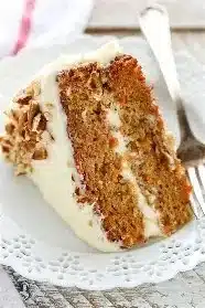 Delicious homemade carrot cake slice with cream cheese frosting and nuts.