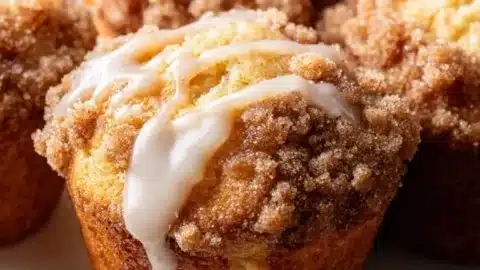 Delicious coffee cake muffins topped with crumbly streusel on a white plate