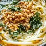 Bowl of delicious Persian noodle soup with herbs and noodles for a cozy night.