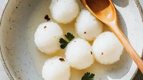 Plate of delicious sticky rice balls garnished with fresh herbs.