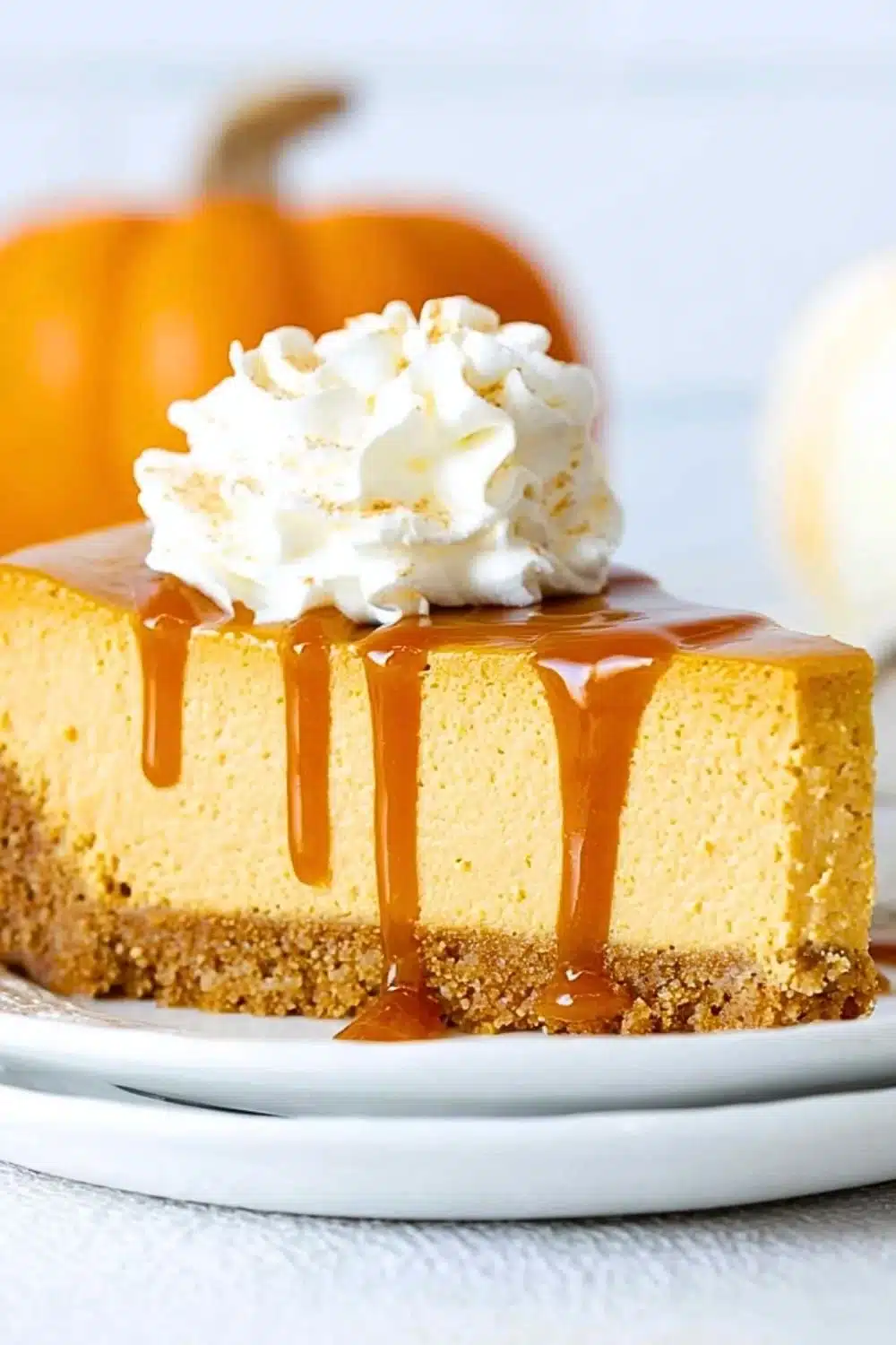 Delicious no bake pumpkin cheesecake topped with whipped cream and spices