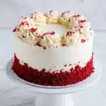 Delicious red velvet cake with cream cheese frosting on a white plate