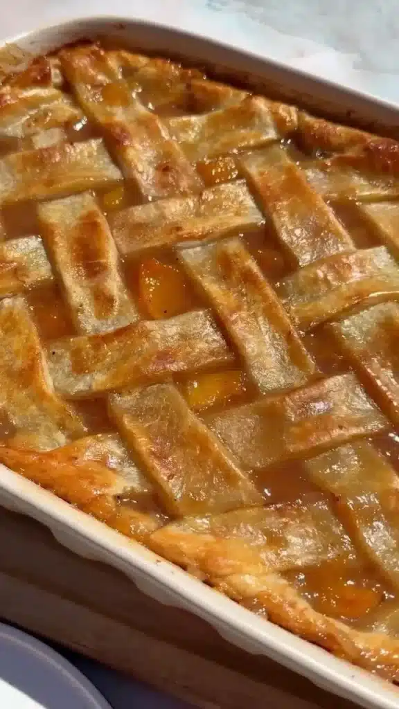 Delicious slice of Southern Peach Cobbler served with vanilla ice cream