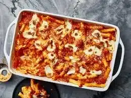 A delicious serving of baked ziti topped with melted cheese and fresh herbs.