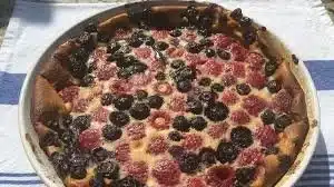 A delicious slice of blueberry cherry clafoutis served on a plate.