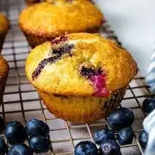 Freshly baked blueberry muffins with juicy blueberries on a wooden table