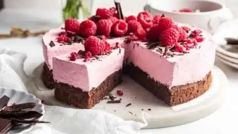 Delicious Chocolate Raspberry Mousse Cake topped with fresh raspberries