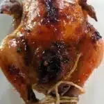 Cornish hen with apricot glaze and wild rice dressing served on a plate