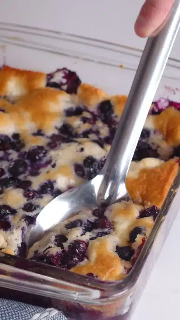 Delicious cream cheese berry cobbler topped with fresh blueberries and strawberries