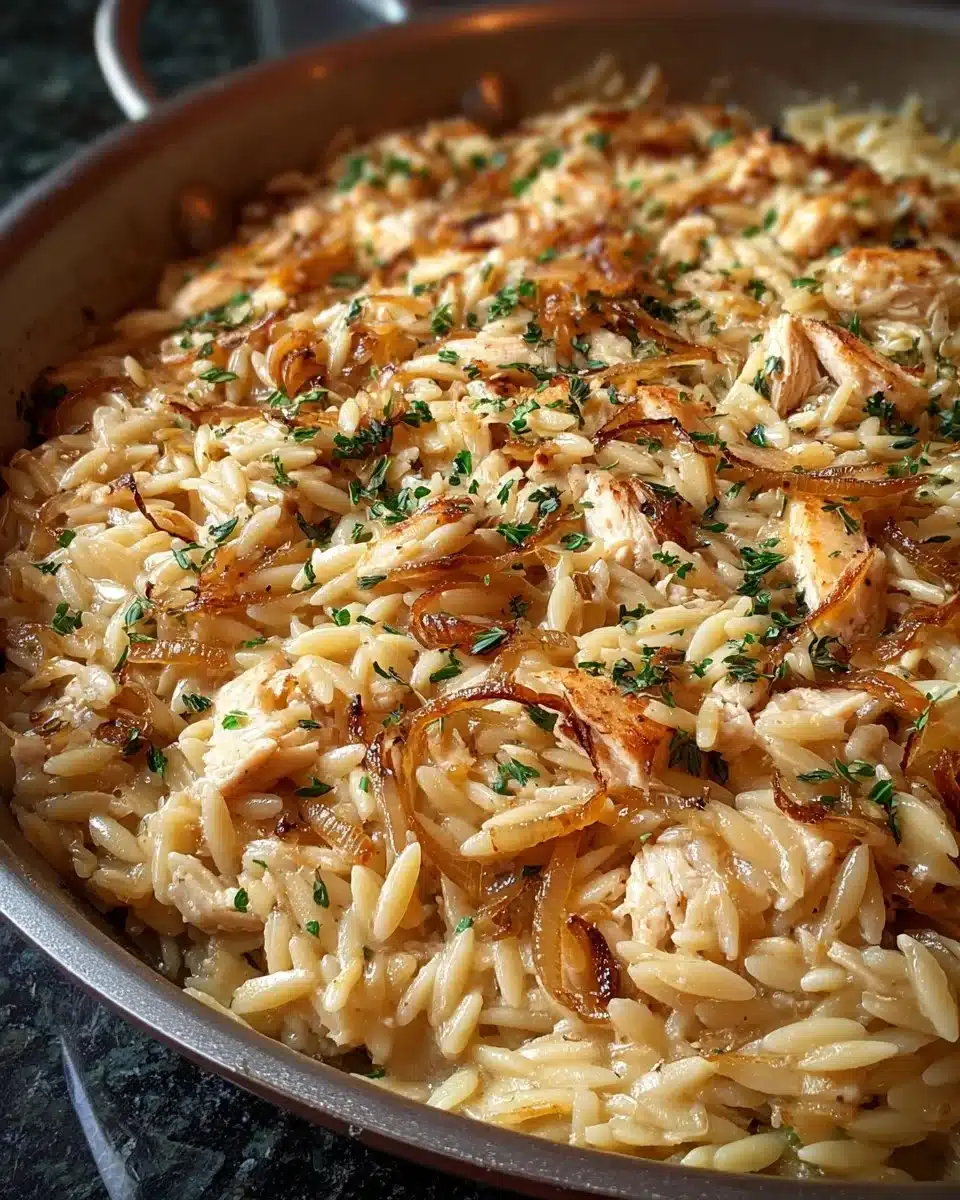 Delicious plate of French Onion Chicken Orzo topped with melted cheese.