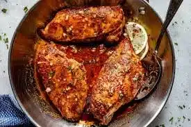 Garlic Butter Baked Chicken Breast garnished with herbs on a plate