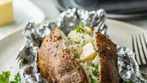 Delicious oven baked potatoes wrapped in foil, ready to serve.