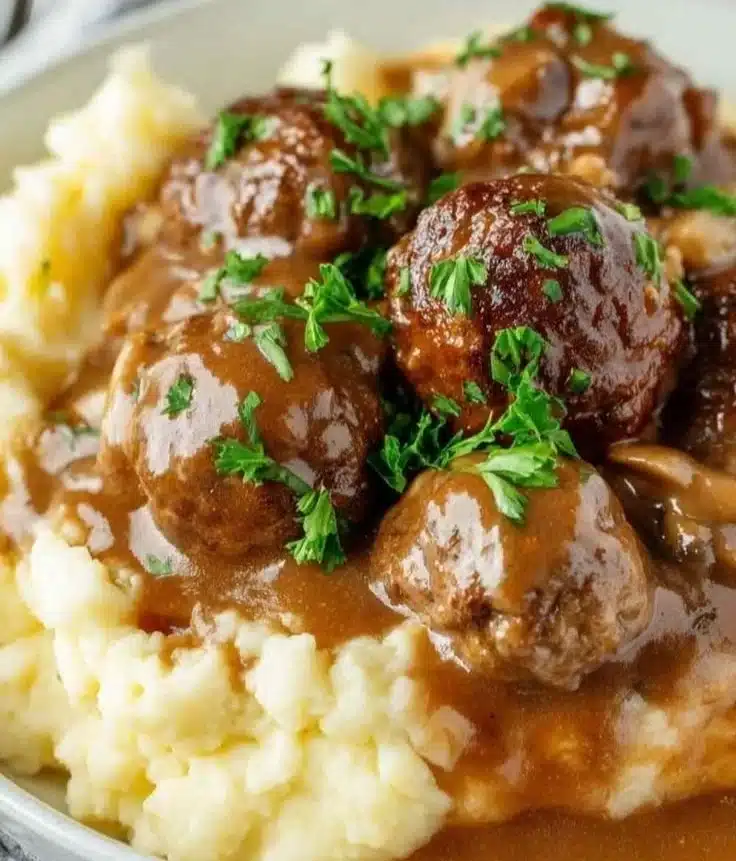 Slow Cooker Salisbury Steak Meatballs served with gravy and vegetables.