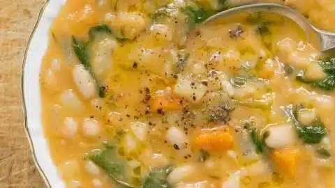 Bowl of the best white bean soup garnished with herbs