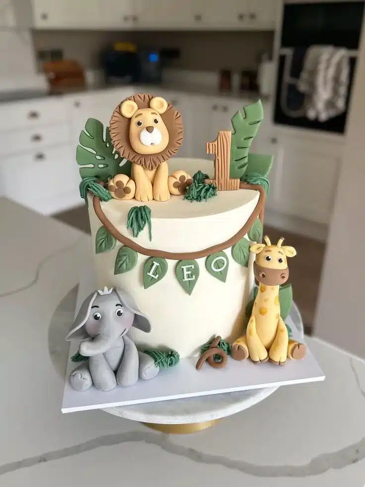 Adorable safari first birthday cake decorated with animals and jungle themes