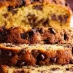 A freshly baked loaf of easy banana bread with sliced bananas on top.