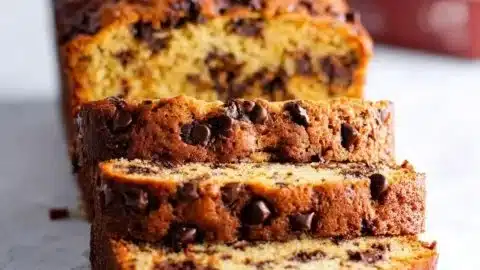 A freshly baked loaf of easy banana bread with sliced bananas on top.