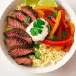 Delicious steak fajita bowl with grilled beef, peppers, and onions served in a colorful bowl.